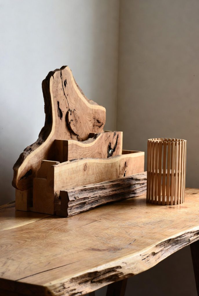 Handcrafted live-edge reclaimed wood pen holder and bamboo cylindrical organizer on desk, sustainable modern-rustic desk decoration idea.